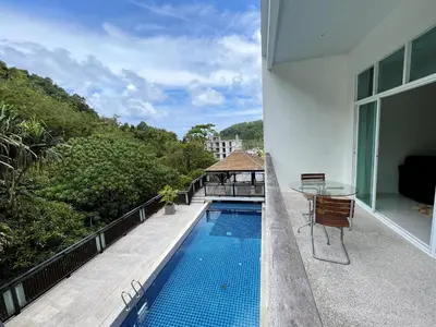 a balcony with a swimming pool and a table at Spacious apartment Kamala Falls by Lofty in Kamala Beach