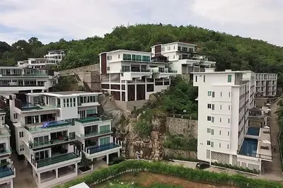 a group of white buildings on a hill with trees at Spacious apartment Kamala Falls by Lofty in Kamala Beach