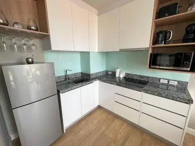 a kitchen with white cabinets and a refrigerator at Mountain view apartment in the heart of BangTao in Bang Tao Beach