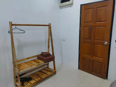 a room with a wooden door and a room with a shelf at Phudis Guest House in Ban Khlong Haeng