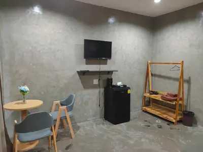 a room with a television and a table and chairs at Phudis Guest House in Ban Khlong Haeng