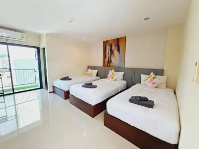 two beds in a room with a window at STAYHERE@AIRPORT SERVICE APARTMENT in Ban Bo Han