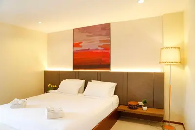 a bedroom with two beds and a painting on the wall at STAYHERE@AIRPORT SERVICE APARTMENT in Ban Bo Han