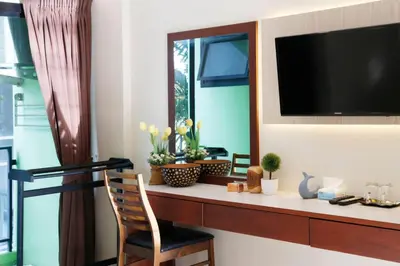a room with a desk with a television and a chair at STAYHERE@AIRPORT SERVICE APARTMENT in Ban Bo Han