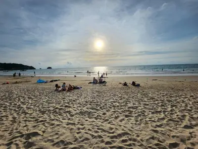 a group of people sitting on a beach at STAYHERE@AIRPORT SERVICE APARTMENT in Ban Bo Han
