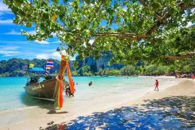 a boat on a beach with people in the water at A401-Silk Condo Aonang, Sea view - 5 mins to beach in Krabi town