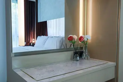 a bathroom with a mirror and a sink with flowers at A401-Silk Condo Aonang, Sea view - 5 mins to beach in Krabi town
