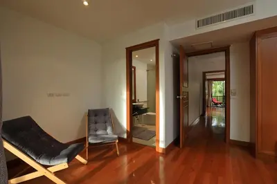 a living room with a chair and a mirror at 2bdr Townhouse in Laguna Village by Capital Pro in Phuket Town