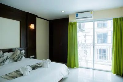 a bedroom with two beds and a large window at Blue Skyline Hotel in Patong Beach