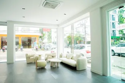a living room with a couch and tables and windows at Blue Skyline Hotel in Patong Beach