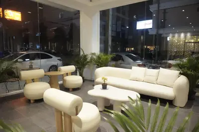 a room with white couches and tables and chairs at Blue Skyline Hotel in Patong Beach