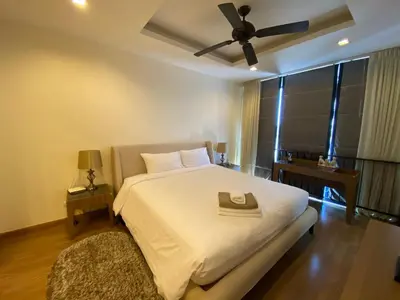 a bedroom with a white bed with a ceiling fan at 2 bdr Townhouse in Laguna Park by CapitalPro in Phuket Town