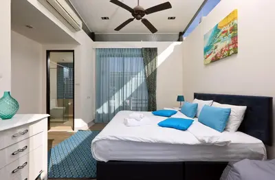 a bedroom with a large bed with blue pillows at 3bdr Townhouse Laguna Park by CapitalPro 131 in Phuket Town