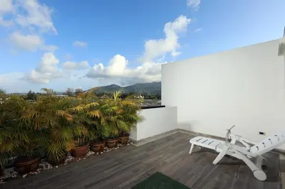 a balcony with a bench and palm trees and mountains at 3bdr Townhouse Laguna Park Bangtao Beach by CapitalPro in Phuket Town