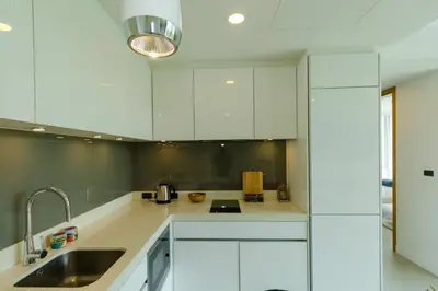 a kitchen with white cabinets and a sink at 2bdr Apartment Oceanstone Laguna by Capital Pro in Phuket Town