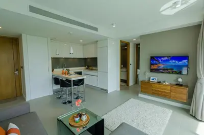 a kitchen and living room with a tv on the wall at 2bdr Apartment Oceanstone Laguna by Capital Pro in Phuket Town