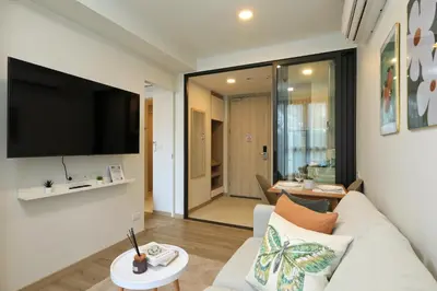 a living room with a couch and a flat screen tv at Bangtao beach Cozy apartments by Capitalpro in Phuket Town