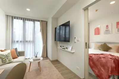 a bedroom with a bed and a couch and a tv at Bangtao beach Cozy apartments by Capitalpro in Phuket Town