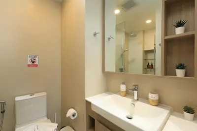 a bathroom with a sink and a toilet and a mirror at Bangtao beach Cozy apartments by Capitalpro in Phuket Town