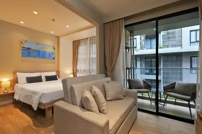 a bedroom with a bed and a chair and a couch at 1bdr Cozy apartment in Diamond Resort Bangtao Beach by Capital Pro in Phuket Town