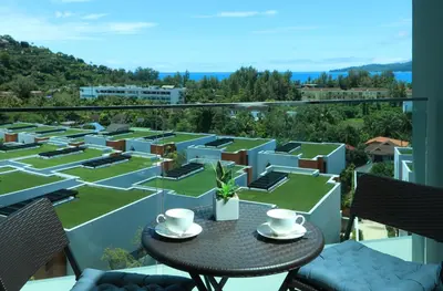 a balcony with a table with two cups on it at 1 bdr Sea view Apartment in Mida Surin Beach by Capital Pro in Phuket Town