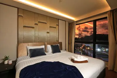 a bedroom with a large bed with a large window at 1 bdr Sea view Apartment in Mida Surin Beach by Capital Pro in Phuket Town