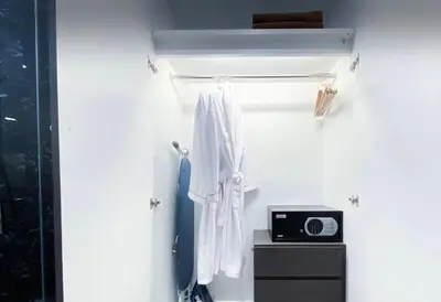 a room with a towel and a clock on a wall at 2 bdr Apartment in Mida Grande Surin Beach by CapitalPro in Phuket Town