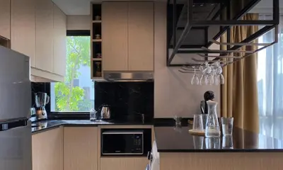 a kitchen with a black counter top and a microwave at 2 bdr Apartment in Mida Grande Surin Beach by CapitalPro in Phuket Town