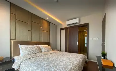 a bedroom with a large bed with a white comforter at 2 bdr Apartment in Mida Grande Surin Beach by CapitalPro in Phuket Town