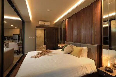 a bedroom with a large bed and a living room at 2bdr Apartment with Jacuzzi SeaView by CapitalPro 307 in Phuket Town