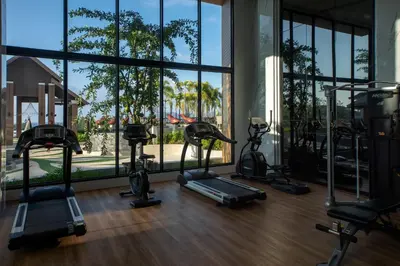 a gym with treadmills and ellipticals in front of a window at 2bdr Apartment with Jacuzzi SeaView by CapitalPro 307 in Phuket Town