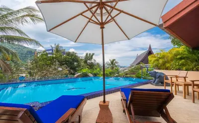 a resort pool with chairs and an umbrella at Villa Malee , Sea View Infinity Pool, Staff, Chef in Kata Beach