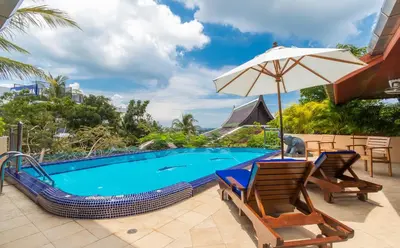 a swimming pool with two chairs and an umbrella at Villa Malee , Sea View Infinity Pool, Staff, Chef in Kata Beach