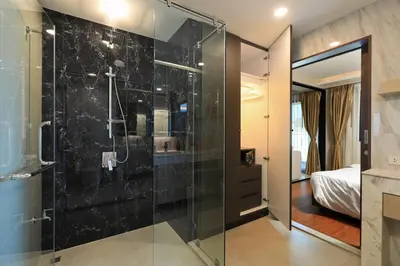a bathroom with a glass shower and a bedroom at 3bdr SeaView Apartment in Surin Beach by Capital Pro in Phuket Town