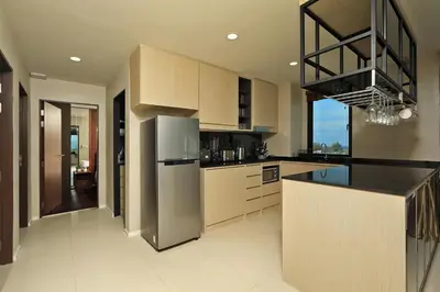 a kitchen with a refrigerator and a counter top at 3bdr SeaView Apartment in Surin Beach by Capital Pro in Phuket Town