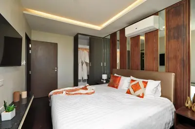 a bedroom with a large bed with white sheets at 3bdr SeaView Apartment in Surin Beach by Capital Pro in Phuket Town