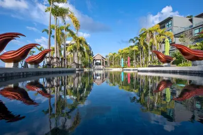 a pool of water with palm trees and buildings at 3bdr SeaView Apartment in Surin Beach by Capital Pro in Phuket Town