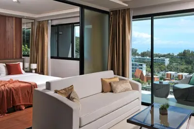 a bedroom with a white couch and a large window at 3 bdr SeaView Apartment walking to Surin Beach by CapitalPro in Phuket Town