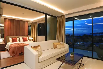 a living room with a bed and a white couch at 3 bdr SeaView Apartment walking to Surin Beach by CapitalPro in Phuket Town