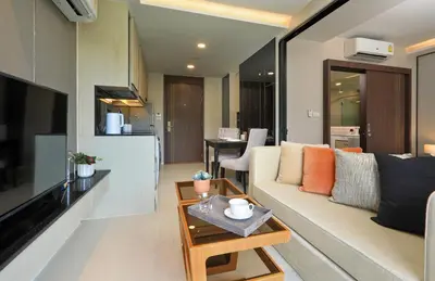 a living room with a couch and a table at Mountain view Apartment Surin Beach 716 by CapitalPro in Phuket Town