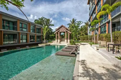 a swimming pool in front of a building at Mountain view Apartment Surin Beach 716 by CapitalPro in Phuket Town