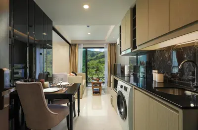 a kitchen with a table and a dining room at Mountain view Apartment Surin Beach 716 by CapitalPro in Phuket Town