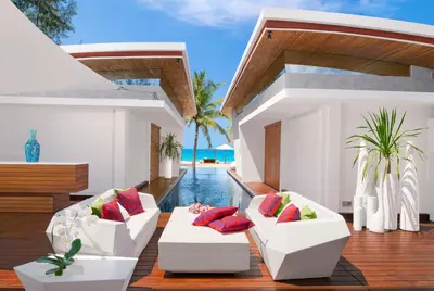 a living room with two white couches and a pool at Iniala Beach House in Natai Beach