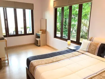 a bedroom with a large bed with large windows at 1 bedroom Villa on Ao Yon beach with sea views in Phuket Town