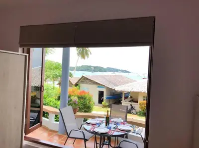 a room with a table and chairs on a balcony at 1 bedroom Villa on Ao Yon beach with sea views in Phuket Town