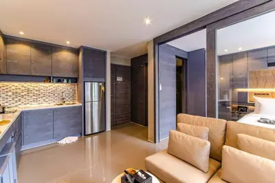 a living room with a couch and a kitchen at Kamala Beach D49 Exclusive Junior Suite in Kamala Beach