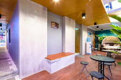 a restaurant with tables and stools in a room at Chalong - Studio Service Apartment - Phoomjai in Ban Klang