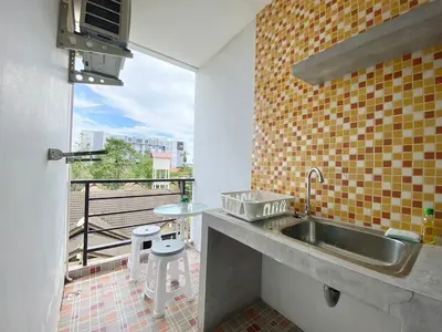 a kitchen with a sink and a balcony at Chalong - Studio Service Apartment - Phoomjai in Ban Klang
