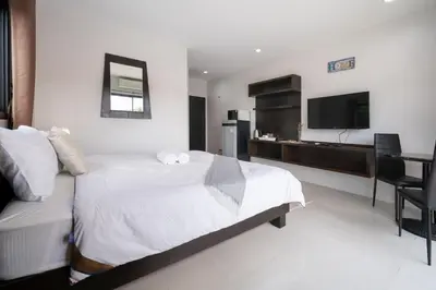 a hotel room with a bed and a television at SD Residence I Naiyang Beach I HKT Airport in Nai Yang Beach