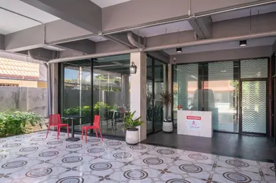 a lobby with a table and two red chairs at SD Residence I Naiyang Beach I HKT Airport in Nai Yang Beach